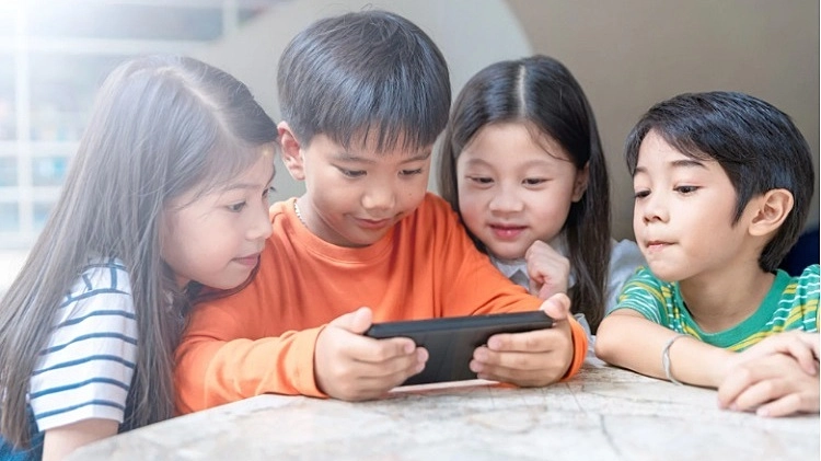 スマートフォンを使用するベトナムの子どもたち（画像出所）VnExpress